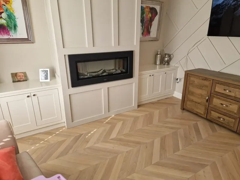Herringbone floor in a panelled living room with an inset fireplace
